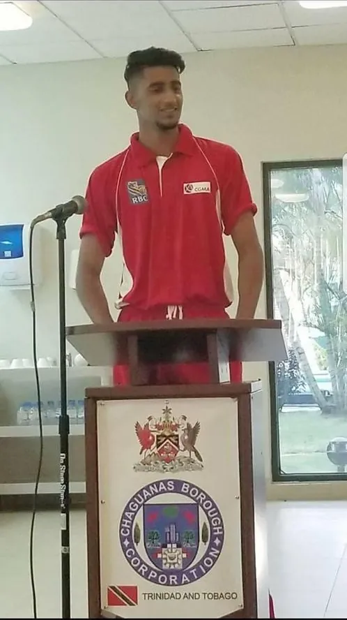 Speaking at a podium in Trinidad
